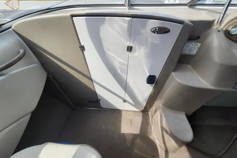 Slide: The Image of Interior view of a 2017 Bayliner 210 Cuddy boat, featuring cabin door and seating area. - 17