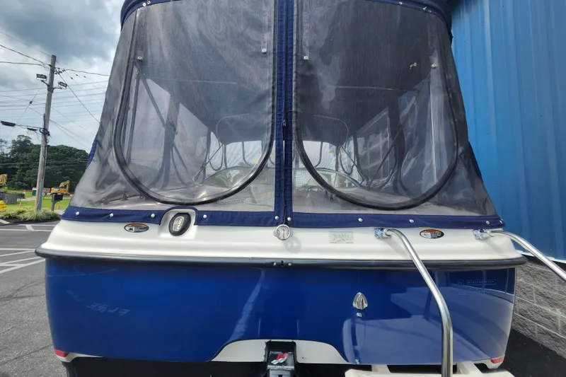 Slide: The Image of 2017 Bayliner 210 Cuddy boat with blue hull and protective canopy. - 6