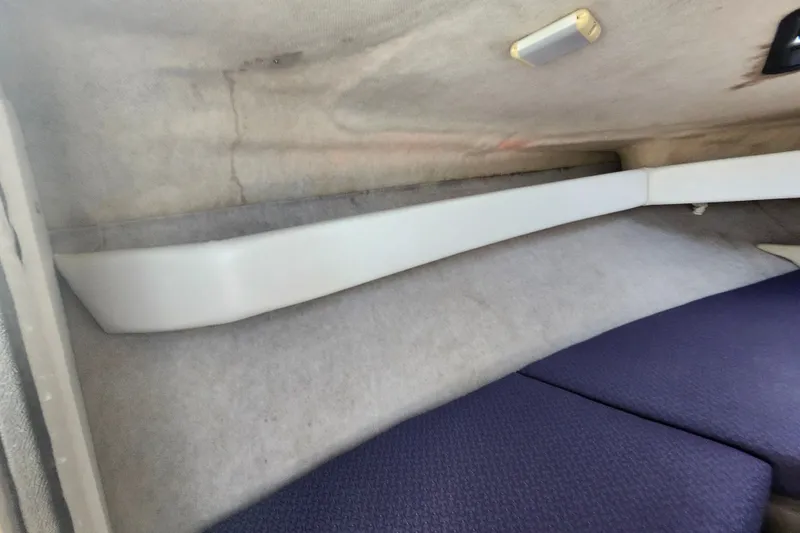 Slide: The Image of Interior view of a 2017 Bayliner 210 Cuddy boat cabin with cushioned seating. - 21