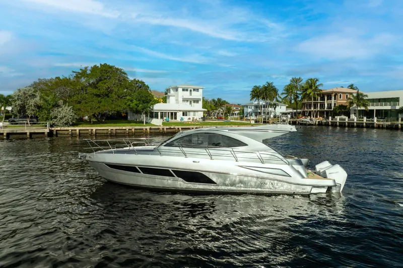 Slide: The Image of Valiatt 410HT 2025 yacht cruising on a scenic waterfront with palm trees. - 15