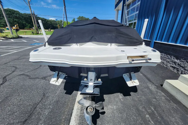 Slide: The Image of 2012 Chaparral 196 SSi boat with cover, parked outdoors on a sunny day. - 5