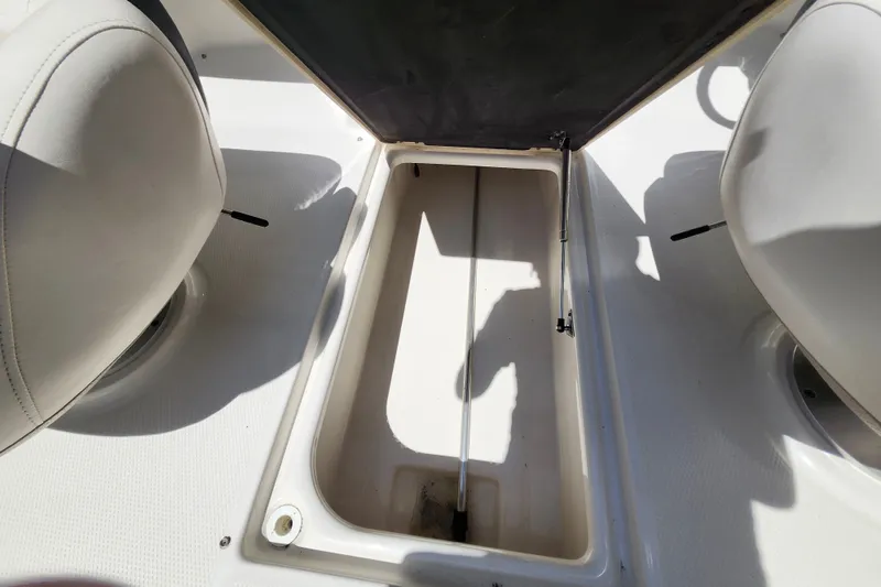 Slide: The Image of Storage compartment in a 2012 Chaparral 196 SSi boat, open between two seats. - 19