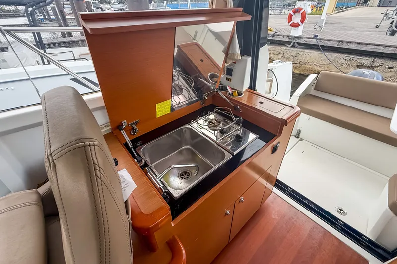 Slide: The Image of 2016 Jeanneau Merry Fisher 855 boat interior with compact kitchen and sink. - 16