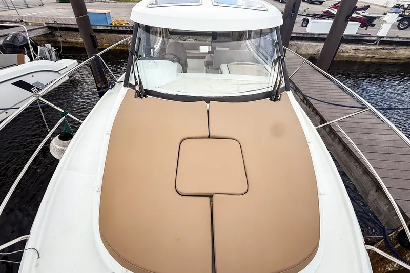 Slide: The Image of 2016 Jeanneau Merry Fisher 855 boat with tan sunpad, docked at marina. - 33