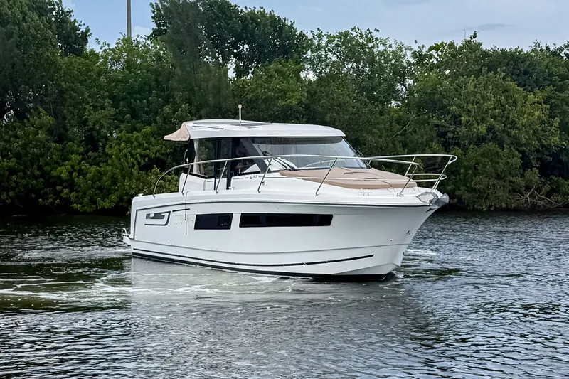 Slide: The Image of 2016 Jeanneau Merry Fisher 855 cruising on a calm river, surrounded by lush greenery. - 1