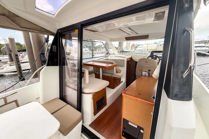 Slide: The Image of Interior view of 2016 Jeanneau Merry Fisher 855 boat, featuring seating and helm station. - 12