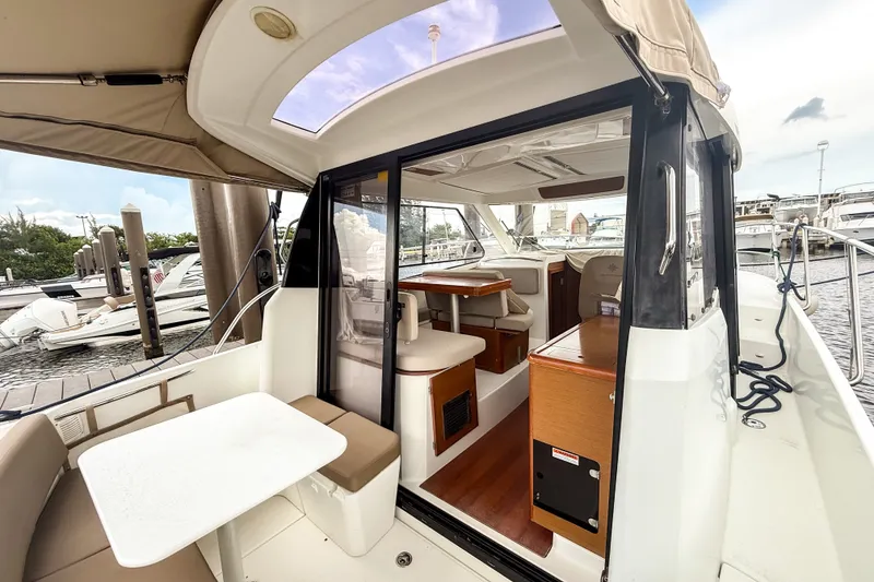 Slide: The Image of 2016 Jeanneau Merry Fisher 855 boat interior with seating and table at marina. - 11