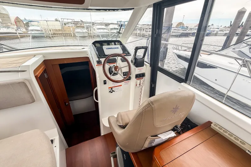 Slide: The Image of Interior helm of 2016 Jeanneau Merry Fisher 855 boat, featuring steering wheel and navigation equipment. - 19