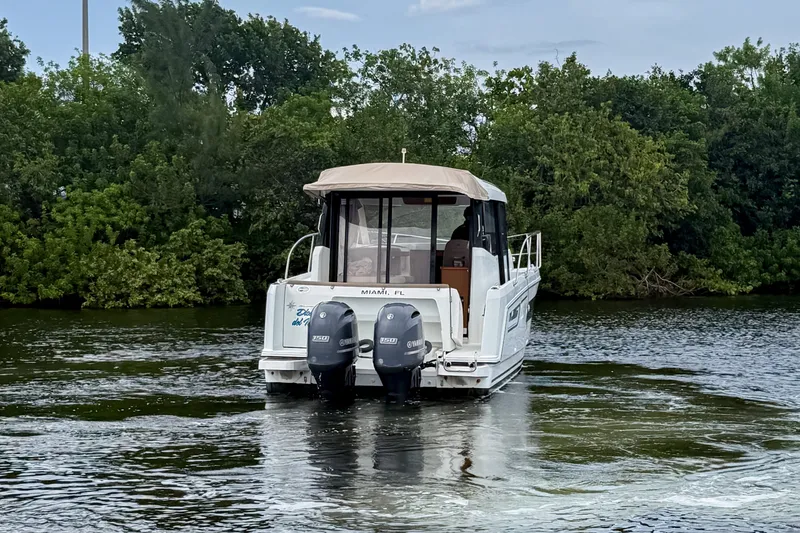 Slide: The Image of 2016 Jeanneau Merry Fisher 855 boat with dual Yamaha engines on a calm waterway. - 5