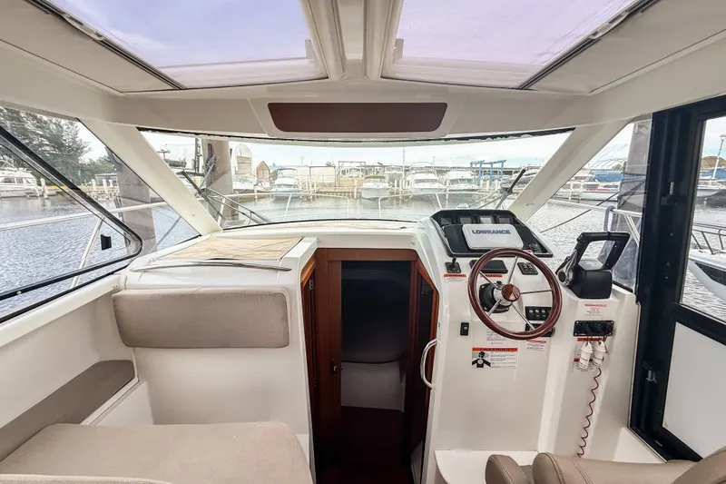 Slide: The Image of Interior view of 2016 Jeanneau Merry Fisher 855 boat cockpit with steering wheel and navigation equipment. - 26