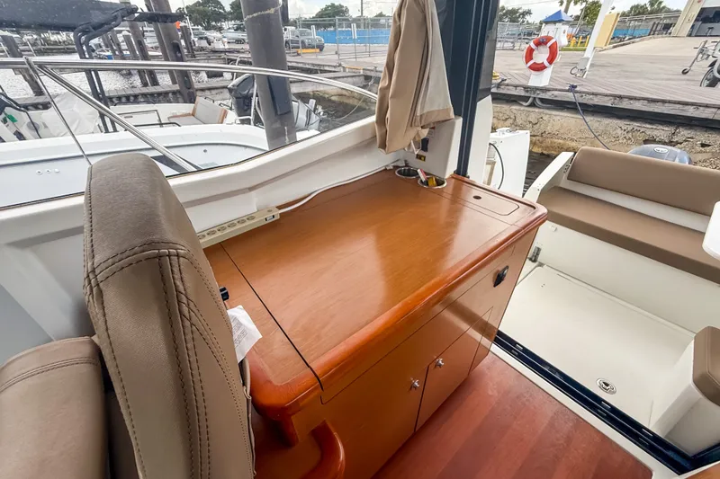 Slide: The Image of Interior of 2016 Jeanneau Merry Fisher 855 boat with wooden cabinetry and seating area. - 15