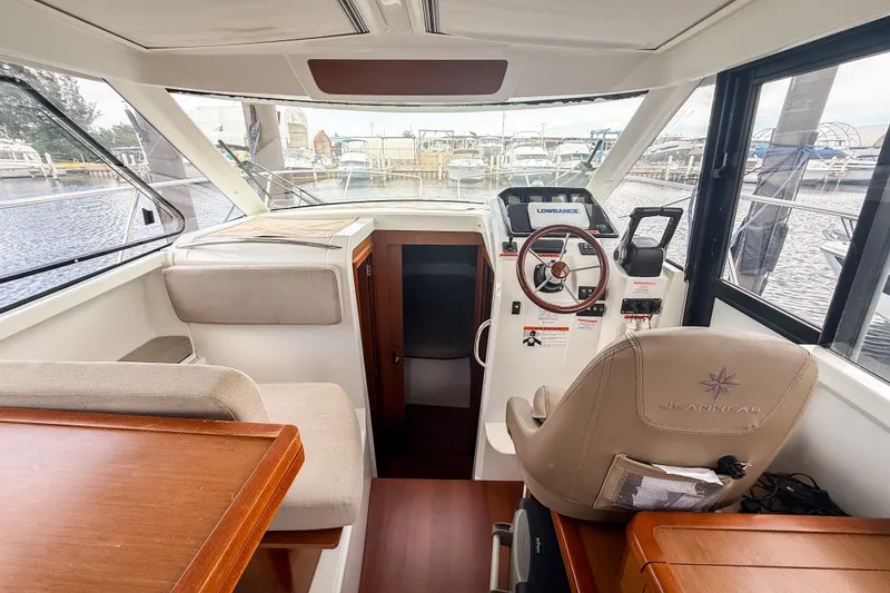 Slide: The Image of Interior of 2016 Jeanneau Merry Fisher 855 boat with helm and seating area. - 18
