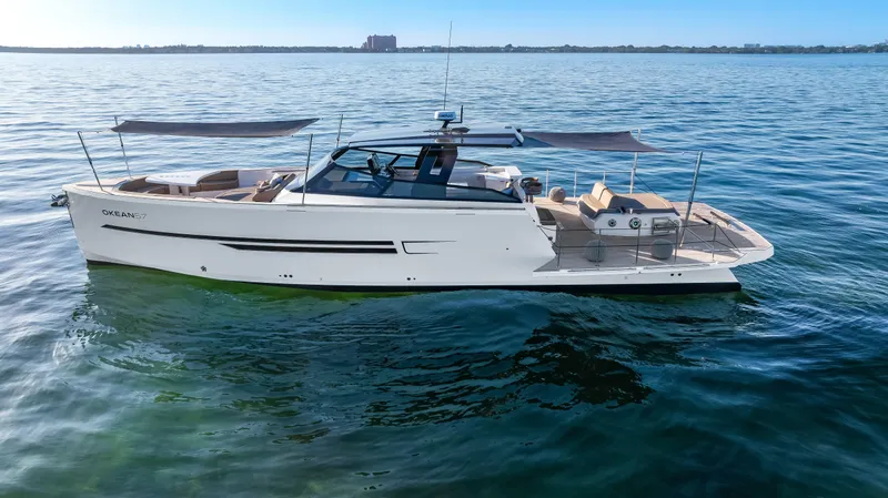 Slide: The Image of Luxury 2026 OKEAN 57 yacht on calm blue waters, featuring sleek design and spacious deck. - 17