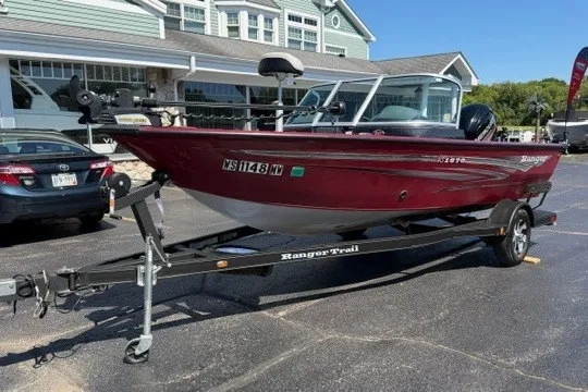 The Image of 2018 Ranger VS1670 SC fishing boat on trailer, parked in front of a building. - 1