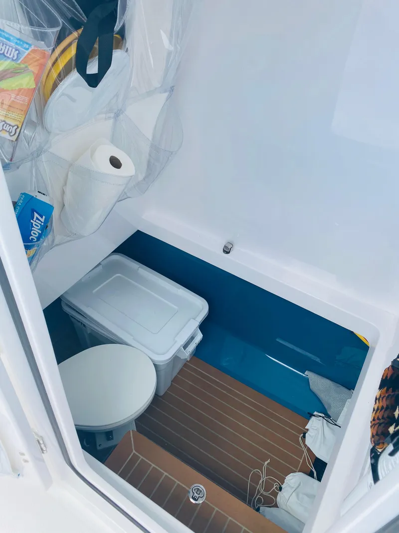 Slide: The Image of A small storage area with a toilet, a plastic bin, and various household items. - 14