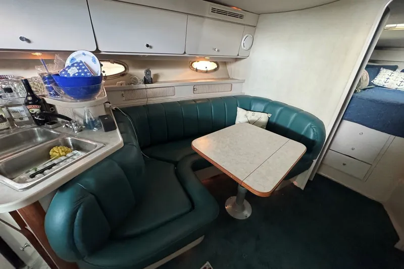 Slide: The Image of 1994 Regal Commodore 400 interior with green seating, kitchenette, and cozy dining area. - 23