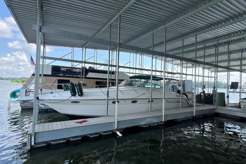 Slide: The Image of 1994 Regal Commodore 400 docked under a covered marina on a sunny day. - 1