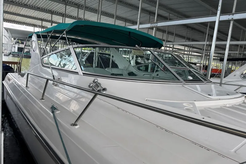 Slide: The Image of 1994 Regal Commodore 400 boat docked under a covered marina, featuring sleek design and green canopy. - 11
