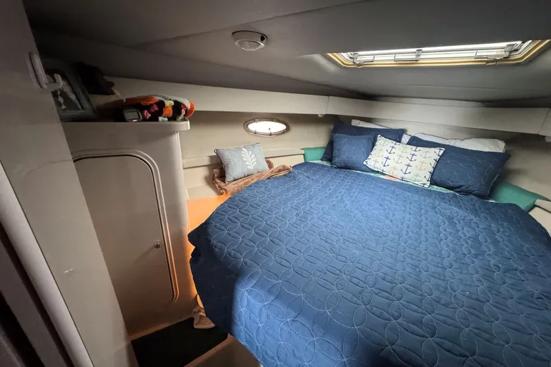 Slide: The Image of Cozy cabin interior of 1994 Regal Commodore 400 with blue bedding and nautical decor. - 29