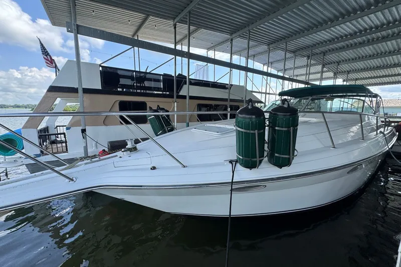 Slide: The Image of 1994 Regal Commodore 400 boat docked under a covered marina with clear skies. - 6