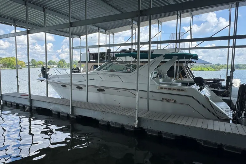 Slide: The Image of 1994 Regal Commodore 400 yacht docked in a covered marina on a sunny day. - 4