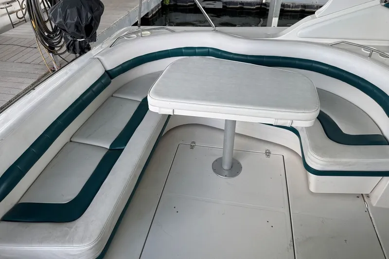 Slide: The Image of 1994 Regal Commodore 400 boat interior with white and teal seating and table. - 13