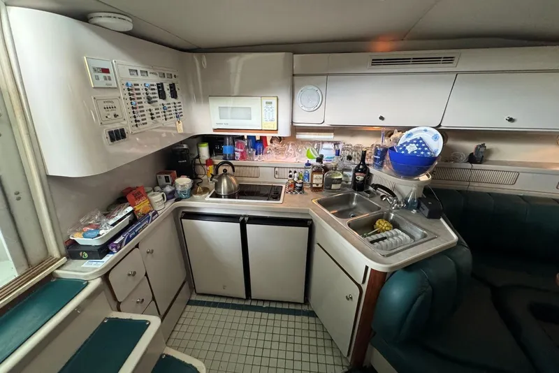 Slide: The Image of Compact kitchen in a 1994 Regal Commodore 400 yacht, featuring appliances and storage. - 31