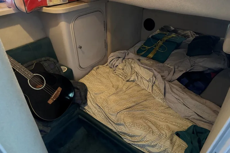 Slide: The Image of Cozy cabin interior of 1994 Regal Commodore 400 with guitar and bedding. - 36