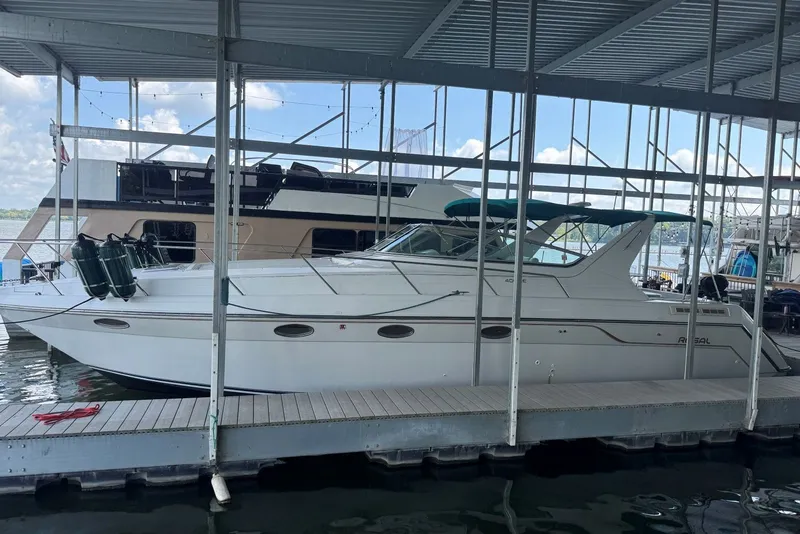Slide: The Image of 1994 Regal Commodore 400 yacht docked in a marina under a covered structure. - 2