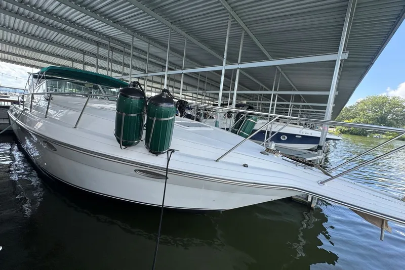 Slide: The Image of 1994 Regal Commodore 400 boat docked under a metal canopy. - 8