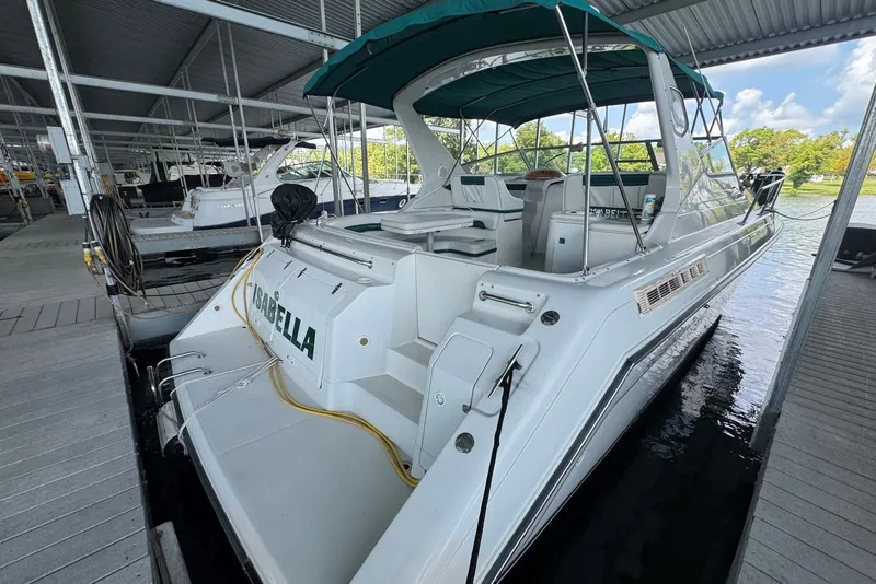 Slide: The Image of 1994 Regal Commodore 400 boat docked under a covered marina, featuring green canopy. - 7