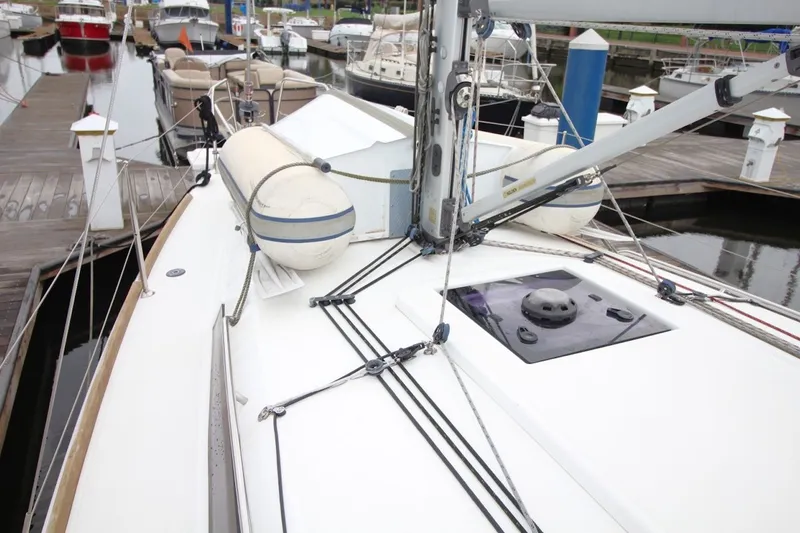 Slide: The Image of 2015 Jeanneau Sun Odyssey 349 sailboat docked at marina, showcasing deck and rigging. - 12