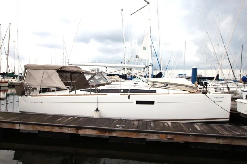 Slide: The Image of 2015 Jeanneau Sun Odyssey 349 sailboat docked at marina under cloudy sky. - 3