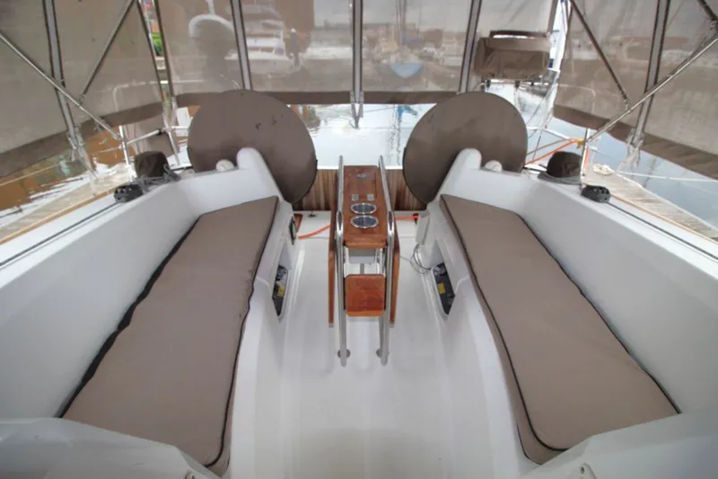 Slide: The Image of 2015 Jeanneau Sun Odyssey 349 cockpit with cushioned seating and wooden table. - 19
