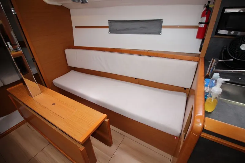 Slide: The Image of Interior of 2015 Jeanneau Sun Odyssey 349 yacht with wooden furnishings and white seating. - 23