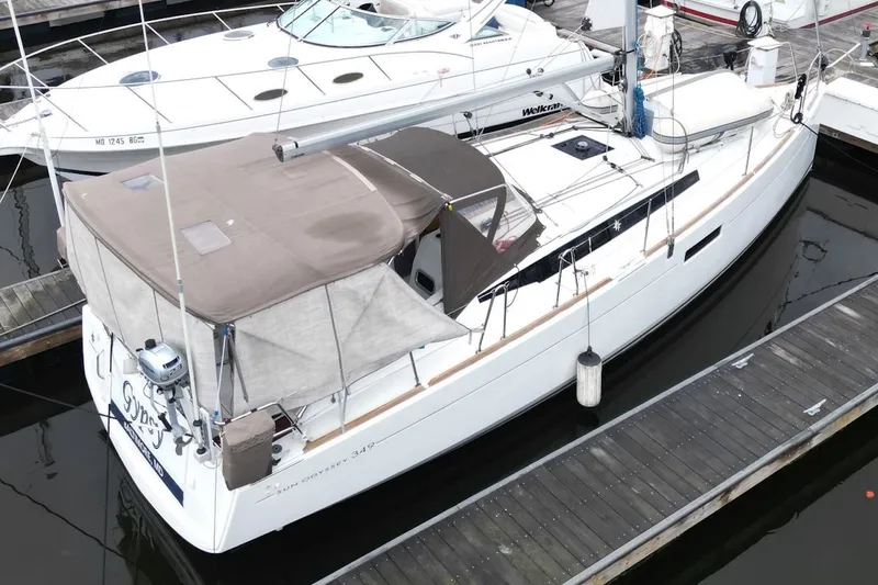 Slide: The Image of 2015 Jeanneau Sun Odyssey 349 sailboat docked in marina, covered with beige canopy. - 9