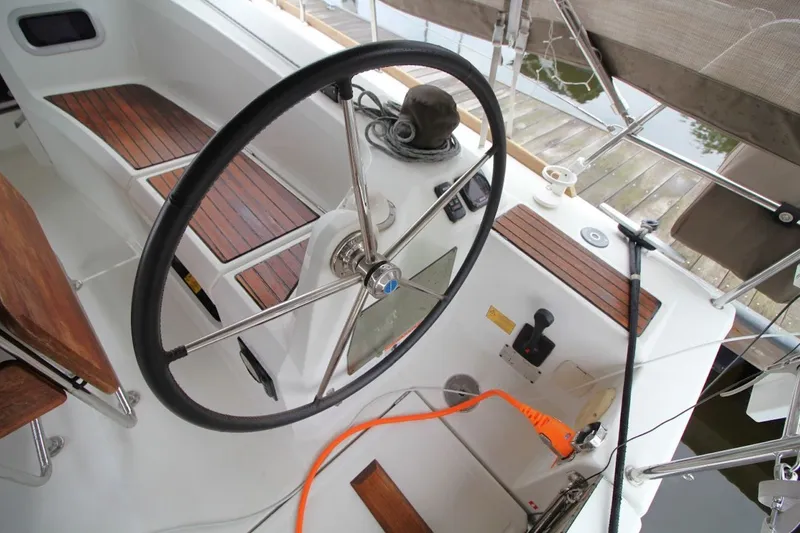 Slide: The Image of Steering wheel and cockpit of 2015 Jeanneau Sun Odyssey 349 sailboat, featuring teak accents. - 17