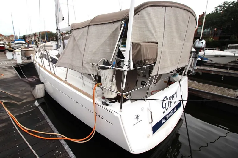 Slide: The Image of 2015 Jeanneau Sun Odyssey 349 sailboat docked at marina, covered with canvas. - 6