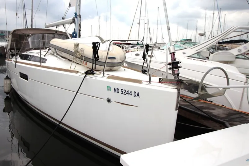 Slide: The Image of 2015 Jeanneau Sun Odyssey 349 sailboat docked in marina, featuring sleek design and white hull. - 5