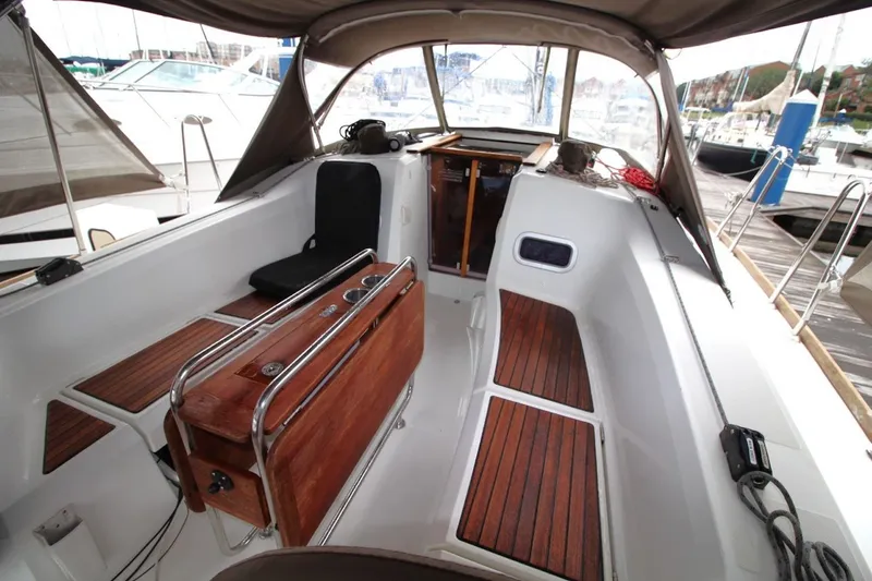 Slide: The Image of 2015 Jeanneau Sun Odyssey 349 cockpit with wooden flooring and seating, docked at marina. - 16