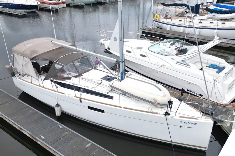 Slide: The Image of 2015 Jeanneau Sun Odyssey 349 sailboat docked at marina, surrounded by other boats. - 8