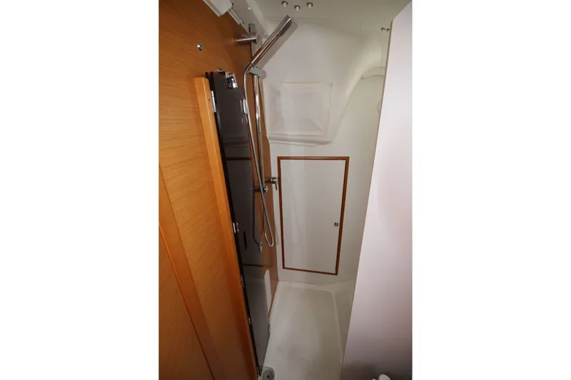 Slide: The Image of Bathroom interior of 2015 Jeanneau Sun Odyssey 349 yacht, featuring a shower and wooden accents. - 28