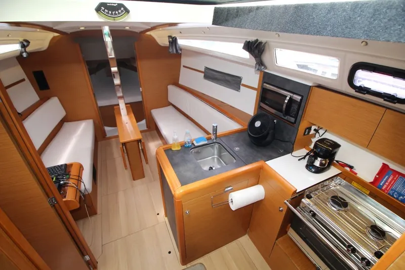 Slide: The Image of Interior of 2015 Jeanneau Sun Odyssey 349 sailboat with modern kitchen and seating area. - 21