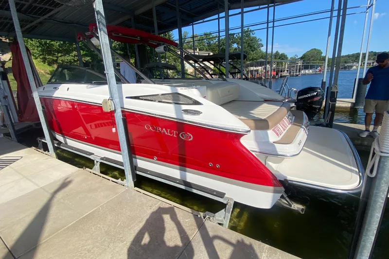 Slide: The Image of 2010 Cobalt 302 boat in dock, red and white exterior, sunny day. - 51