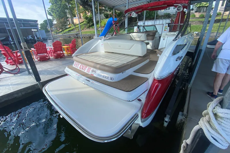 Slide: The Image of 2010 Cobalt 302 boat docked, featuring red and white design with spacious seating. - 10