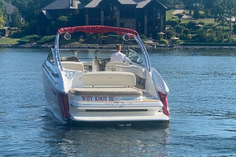 Slide: The Image of 2010 Cobalt 302 boat on a lake, labeled "Why Knot III," near a scenic shoreline. - 7