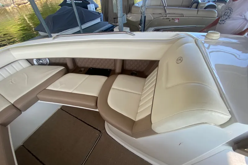 Slide: The Image of 2010 Cobalt 302 boat interior with beige and white seating, docked near water. - 35