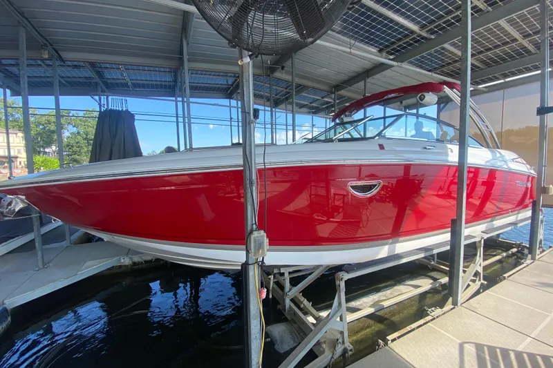 Slide: The Image of Red 2010 Cobalt 302 boat on lift in covered dock area. - 50