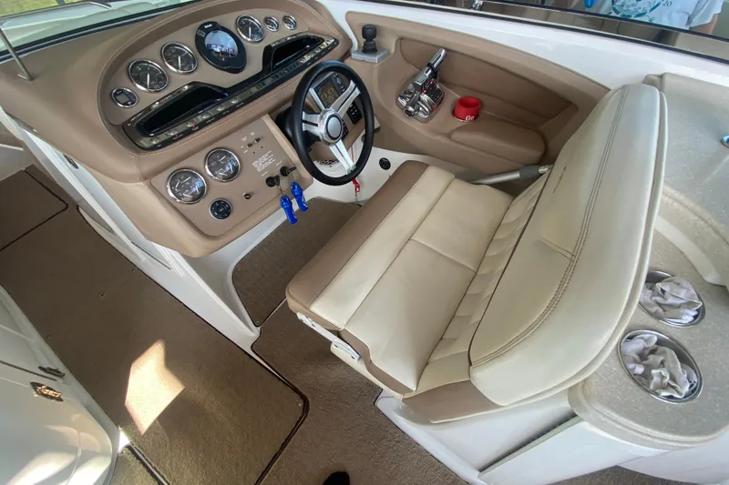 Slide: The Image of 2010 Cobalt 302 boat interior with beige dashboard and steering wheel. - 29