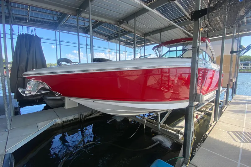 Slide: The Image of 2010 Cobalt 302 boat in a dock, featuring a sleek red and white design. - 49